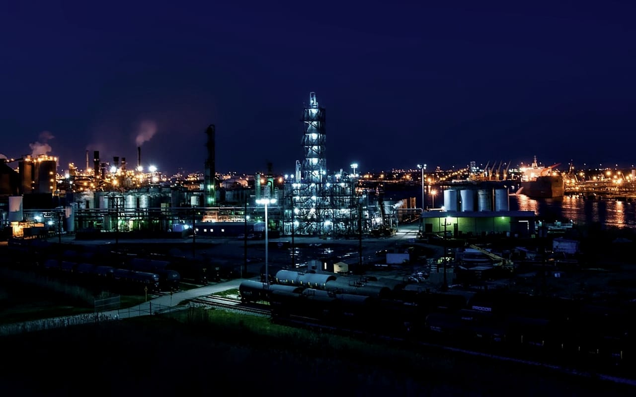 Planta de proceso de petróleo y gas iluminada al anochecer